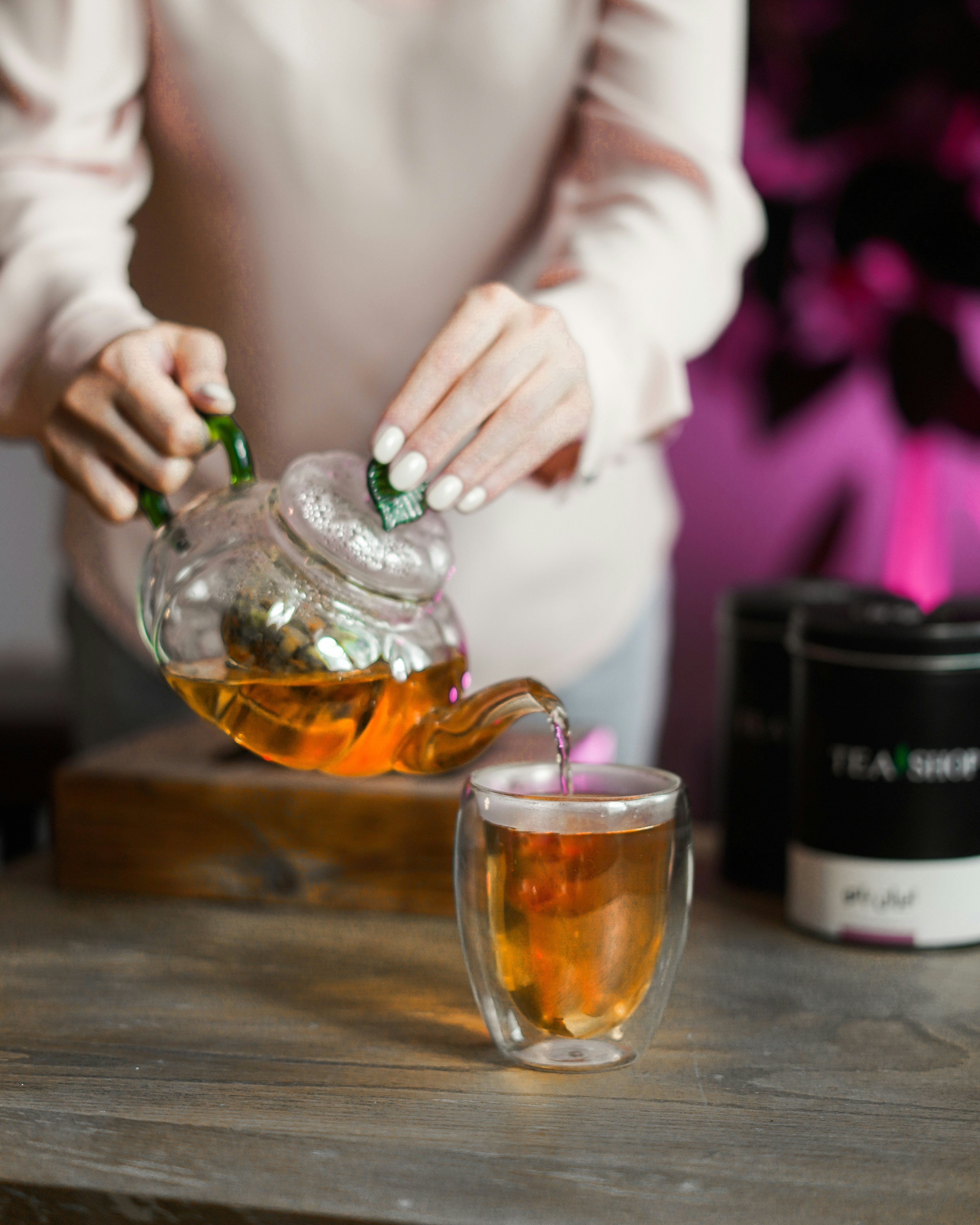 Loose leaf tea being poured from a glass teapot into a glass mug, the kind of moment Postea's letterbox-friendly tea boxes are made for